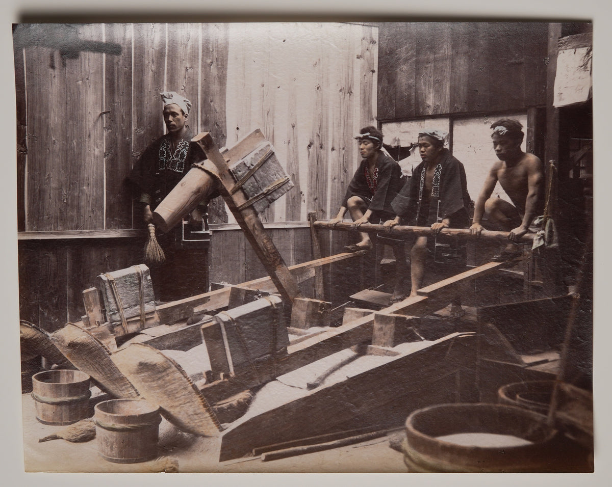 Pounding Rice, hand-colored albumen print attributed to Kusakabe Kimbei: workers at treadle pestles